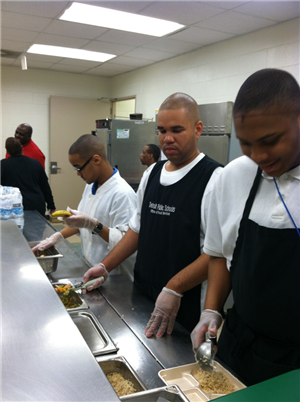 three boys serving food
